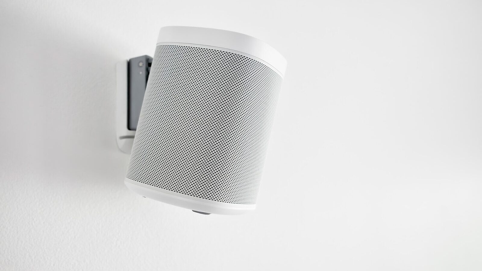 A wall-mounted speaker in a white interior